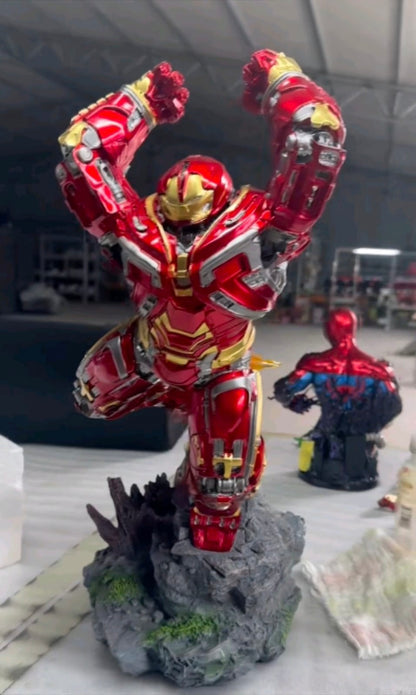 Red and gold Hulkbuster-style Iron Man collectible statue on a rocky display base